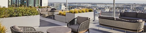A patio with a table and chairs overlooking a cityscape.