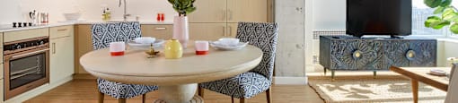 A modern kitchen with a round table and chairs.