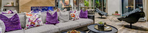 A modern living room with a grey sofa and a black coffee table.