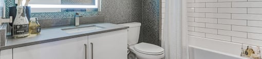 A white toilet sits next to a bathtub in a bathroom.
