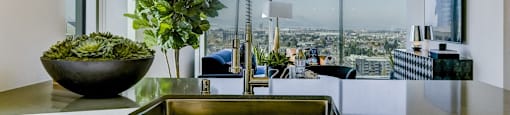 A modern kitchen with a large window overlooking the city.