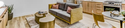 A modern living room with a yellow sofa and a white rug.