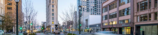 A city street with a tall building in the background.