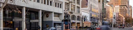 A tall building with a blue top stands next to a building with a mural on it.