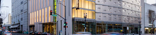 A tall building with many windows is lit up with yellow lights.