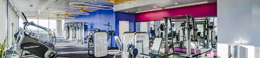 A gym with a variety of equipment including treadmills, stationary bikes, and weight machines.