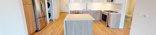 A kitchen with a wooden floor and a white ceiling.