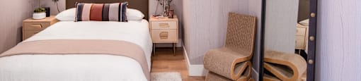 A bedroom with a large bed and a chair.