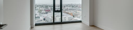 A room with a large window overlooking a cityscape.