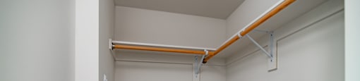 A white room with a shelf and a door.