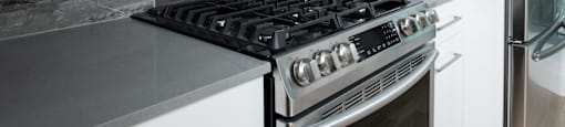 A modern kitchen with a stove and a microwave above it.
