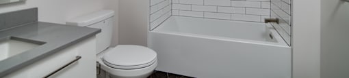 A white bathroom with a toilet, sink, and bathtub.