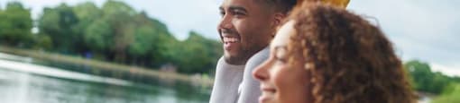 A family of three is enjoying a boat ride on a lake.