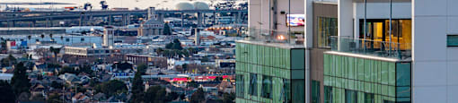 A cityscape with a large body of water and mountains in the background.