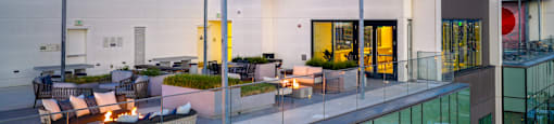 A modern house with a glass balcony and a fire pit.
