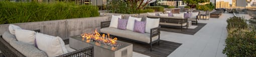A patio with a fire pit and couches.