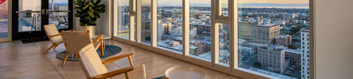 A room with a view of the cityscape at sunset.