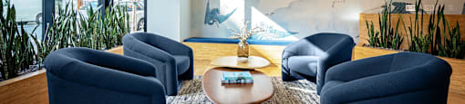 A room with blue chairs and a table with a tray on it.