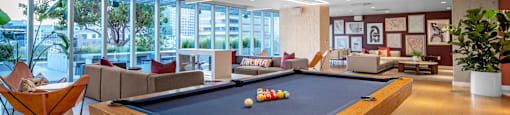 A pool table in a room with a view of the city.