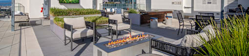 A patio with a fire pit and seating area.