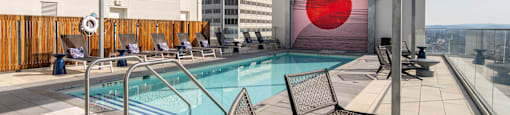 A pool with chairs and a table on a patio.