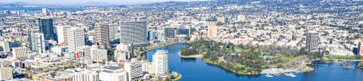 A cityscape with a large body of water in the foreground and a smaller island with buildings.