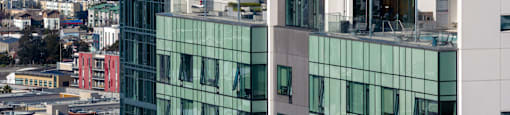 A modern building with glass windows is seen from a distance.