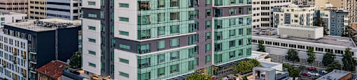 A modern glass building is situated on a busy street.