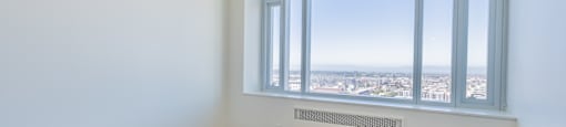 A room with a window overlooking a cityscape.