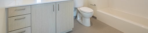 A white bathroom with a toilet, sink, and bathtub.