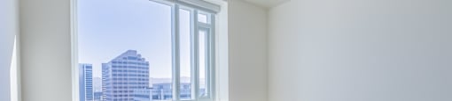 A room with a window overlooking a cityscape.