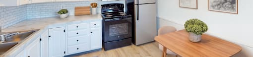 A kitchen with a refrigerator, oven, and sink.