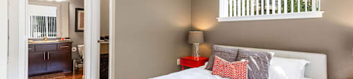 Bedroom with a large bed and a bathroom in the background