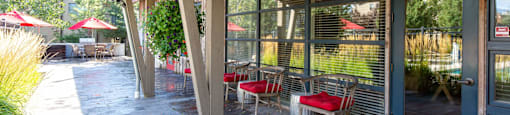 A patio with red cushioned chairs and a blue door at Mullan Reserve Apartments in Missoula, MT