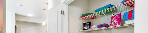 A laundry closet with washer, dryer, and shelves at Mullan Reserve Apartments in Missoula, MT