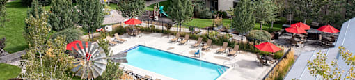 Aerial view of a pool with lounge chairs and umbrellas  at Mullan Reserve Apartments, Missoula, MT, 59808