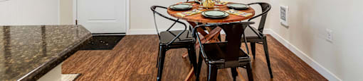 Dining area with a wooden table and chairs and a colorful painting on the wall at Mullan Reserve Apartments in Missoula, MT