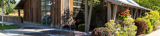 Wooden building with a tin roof and a garden in front of it at Mullan Reserve Apartments in Missoula, MT