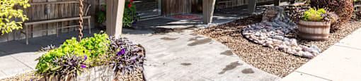 Wooden building with a tin roof and a stone path in front of it at Mullan Reserve Apartments in Missoula, MT