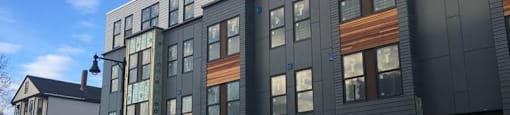 A modern building with a combination of grey and wood panels.