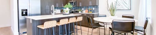 A kitchen with a bar area and a dining table.