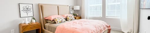 A bedroom with a bed, nightstand, and window.
