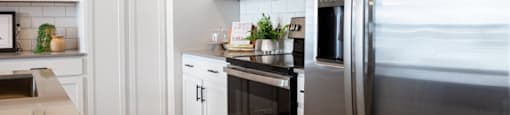 A modern kitchen with stainless steel appliances and white cabinets.