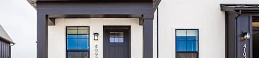 A white house with a black door and windows.