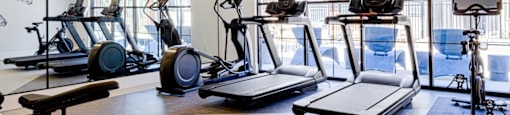 A gym with treadmills, exercise bikes, and elliptical machines.