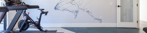 A treadmill is in a room with a wall mural of a map.