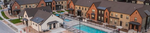 A large housing complex with a swimming pool in the middle.