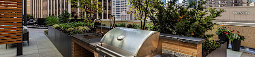 a barbecue grill on a patio with skyscrapers in the background
