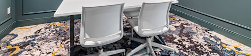a conference room with a table and chairs and a television
