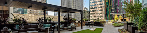 an outdoor lounge area with a lawn and cityscape in the background